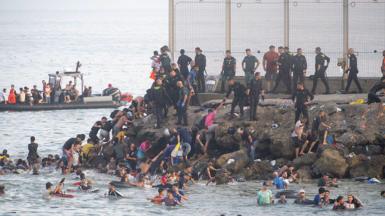 Migrants swimming to shore off Ceuta. 