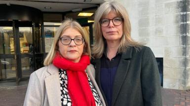 Fiona Elias, left, and Liz Hopkin. They both have spectacles and blond hair. Ms Elias has a beige jacket and red scarf. Ms Hopkin has a dark jacket with a blue and black top beneath it.