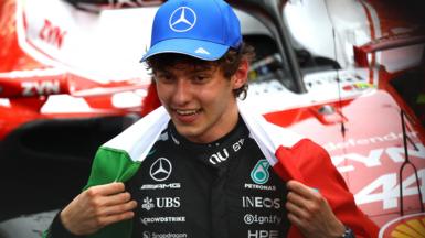 Kimi Antonelli with the Italian flag draped around his shoulders after winning the Monaco Grand Prix