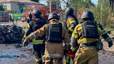Rescuers carry a person killed during Russian drone strikes in the town of Pechenihy, amid Russia's attack on Ukraine in Kharkiv region, Ukraine August 18, 2026