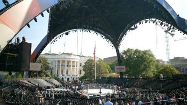 A large structure painted red and blue is in front of the White House on the South Lawn.