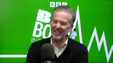 Tim Richards, a 66 year old man, in front of a green backdrop with the BBC Big Boss Interview logo