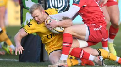 Dragons fly-half Tinus de Beer crashes over for a try against Scarlets