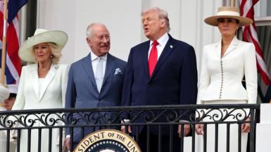 The Queen, King, Donald and Melania Trump stand on the White House balcony in formal attire on Tuesday.