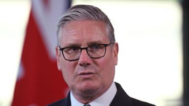Keir Starmer wearing glasses and looking to the right of the frame.