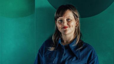 Sabine Zetteler in a blue shirt against a green background