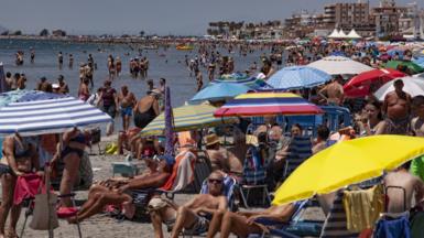 People enjoy a day at the beach in Santa Pola, Alicante