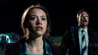 A still from the movie Watch the Skies where a young woman and a man stare into the night sky.