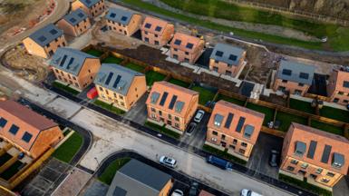 Aerial view of a construction site of residential houses, with plots and roads partially completed 