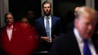 Eric Trump stands in the background at the New York City courthouse