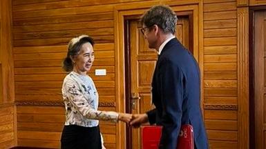 Former Myanmar president Aung San Suu Kyi shakes hands with an official from the International Committee of the Red Cross