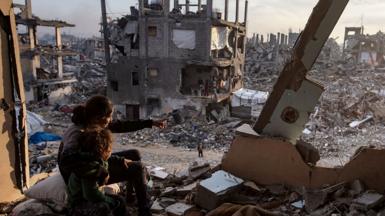 Palestinian children watch the sunset from the destroyed house in Jabalia refugee camp, north of Gaza City (11 February 2025)