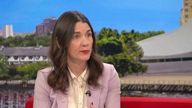 Lauren Schultz from McDonald's on a red sofa wearing a purple jacket