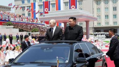 Vladimir Putin and Kim Jong Un standing inside a black Mercedes car
