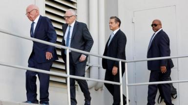 Rupert Murdoch and others walk outside a Reno courthouse