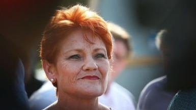 A close up of a woman with short red hair smiling
