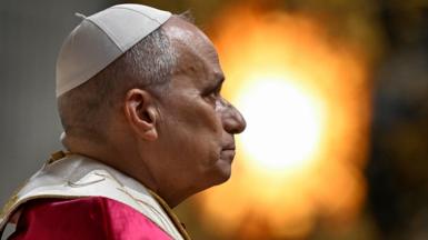 Head shot of Pope Leo, facing right and wearing a papal cap and robes