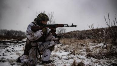 A Ukrainian soldier holds a rifle in the snow