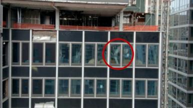 A NYC high-rise building has broken structural beams. In the image, one broken beam is circled in red.