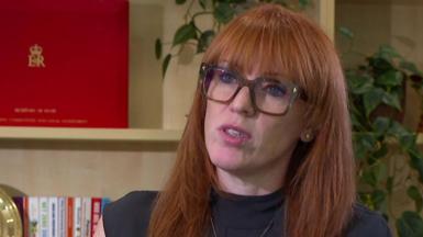 Angela Rayner, a woman with long ginger hair and glasses, against a backdrop with a ministerial red box on a shelf