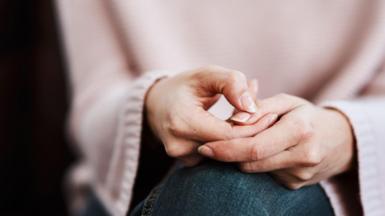 Cropped shot of a woman sitting on a sofa and feeling anxious.