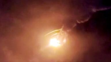 A bright light and clouds of fumes against a dark sky as a rocket explodes.