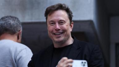 Elon Musk smiles during an appearance at the US Open tennis tournament