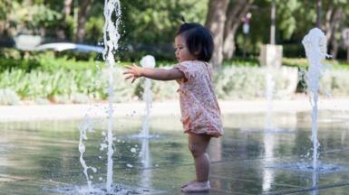 Baby playing with a water fountain