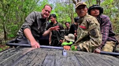 Sommerville and the young rebels on an open top vehicle driving through jungle