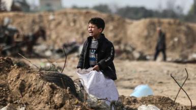 A Palestinian boy cries as he stands amid debris in the Maghazi camp for Palestinian refugees