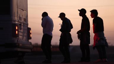 Migrants waiting to board bus in Arizona after crossing from Mexico