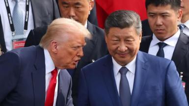 Donald Trump speaks into the ear of Xi Jinping