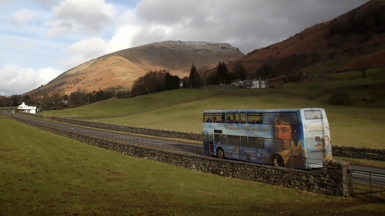 A double decker bus travelling on a country lane