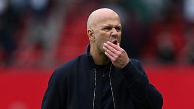 Arne Slot strokes his chin during the defeat to Manchester United