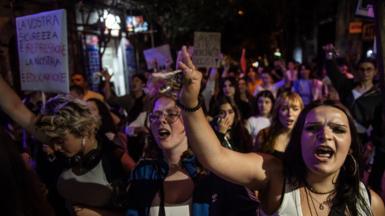 A crowd of women with their fists in the air and holding picket signs with anti-femicide slogans in Italian. This was protest which took place in May 2025 following the murder of Martina Carbonaro. The woman in the foreground is carrying a bunch of keys.