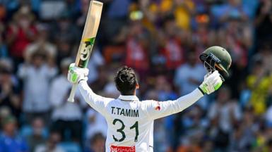 Tanzid Hasan Tamim raising his bat and looking to the sky after reaching his century.