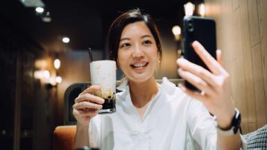 Woman in Hong Kong poses with bubble tea for selfie photo.
