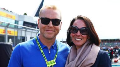 Sir Chris Hoy, wearing sunglasses and a blue top next to a woman in a dark jacket, also wearing sunglasses