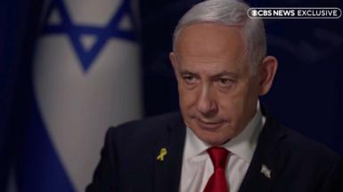 Benjamin Netanyahu is doing an interview with CBS News with an Israeli flag in the back.