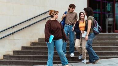 Students chat outside a building. 