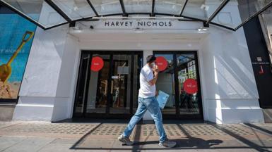 A man walks past the side entrance of the Harvey Nichols department store in Knightsbridge. 