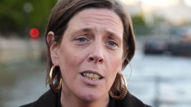 Jess Phillips has short brown hair tucked behind her ears. She is wearing a dark jacket and is forwards.