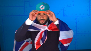 Seydou Traore puts on a Miami Dolphins hat after being selected by the team at the 2026 NFL Draft