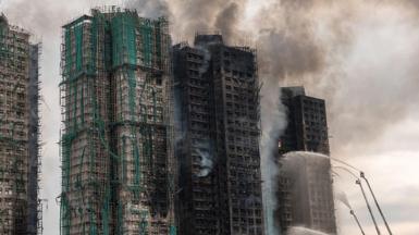 Smoke rises from apartments after a major fire swept through several blocks at the Wang Fuk Court residential estate in Hong Kong's Tai Po district
