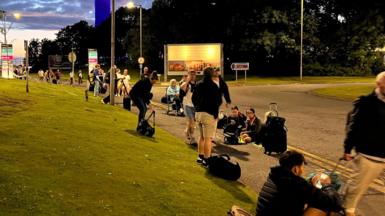 Stranded travellers waiting outside the airport