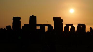 Sun rising over Stonehenge with the stones in silhouette