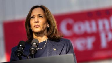 Close up shot of Kamala Harris standing in front of microphones.