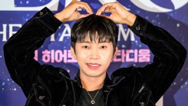 Lim Young-woong gestures a heart shape with both of his arms raised above his head