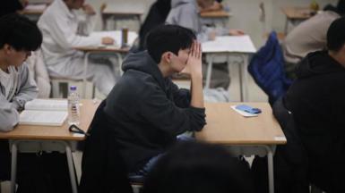 Students wait for the start of the annual college entrance examinations, also known as Suneung, at an exam hall in Seoul