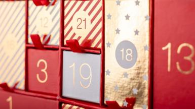 An advent calendar coloured red, white and gold with little drawers for each day